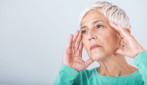 woman with cognitive decline wiht her head in her hands