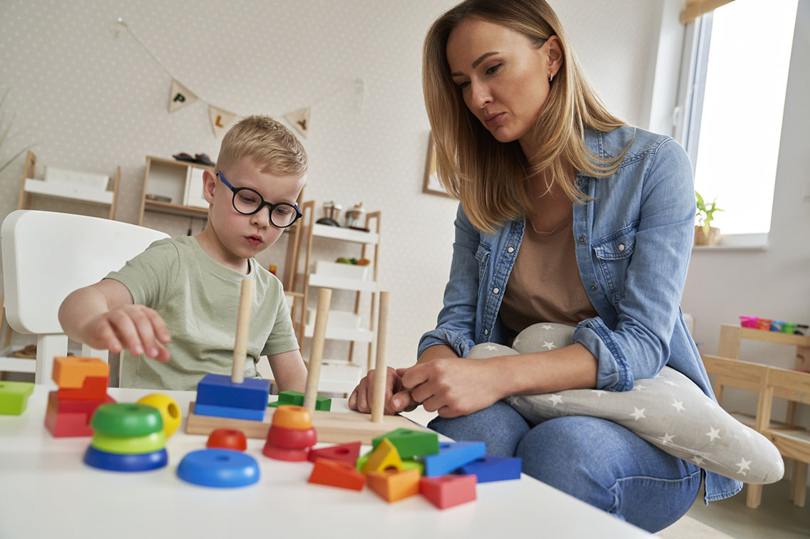 Child with glasses doing ABA therapy with therapist