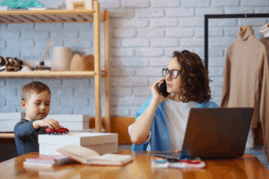 Mom calling clinic to schedule MeRT. Child next to her.