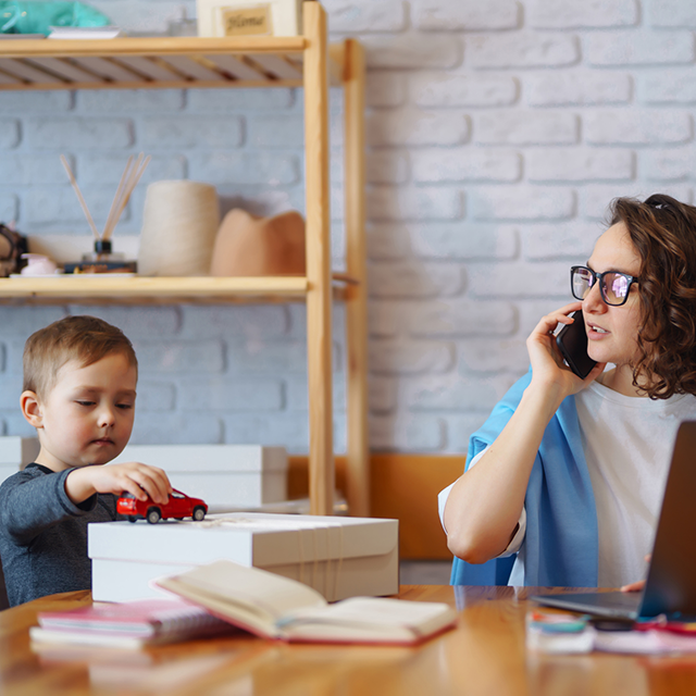 Mom calling clinic to schedule MeRT. Child next to her.