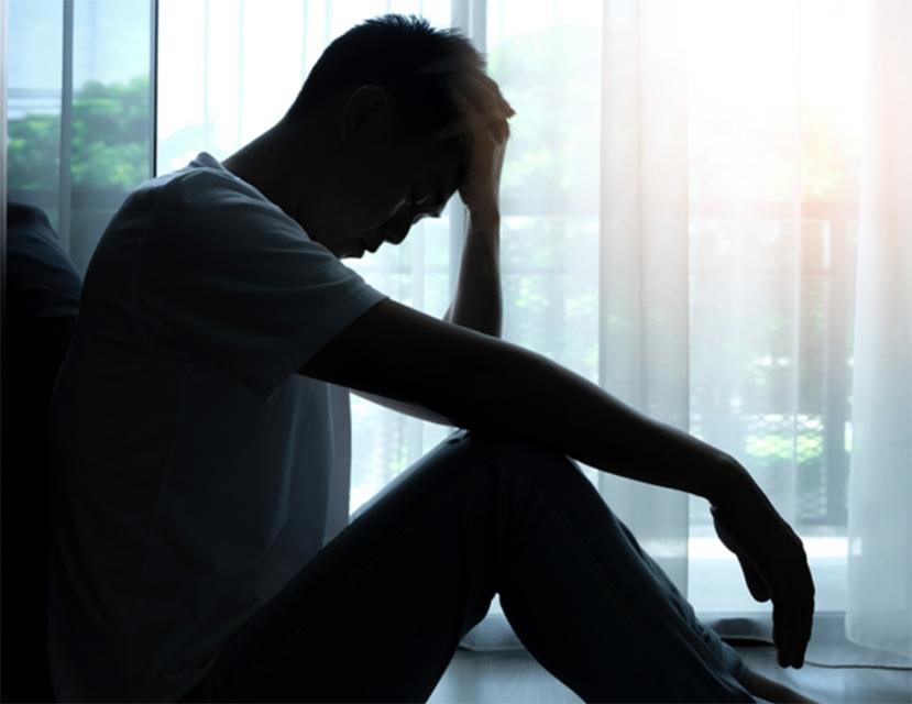 Depressed man with head in hand