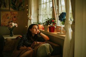 woman with depression looking out window