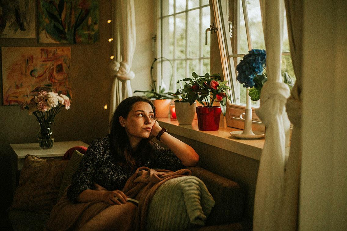 woman with depression looking out window